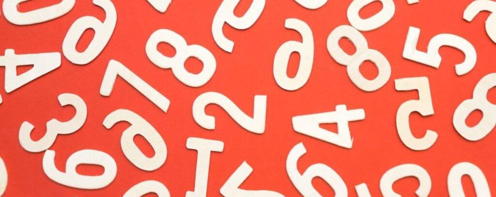 Brojevi razbacani na narančastoj pozadini