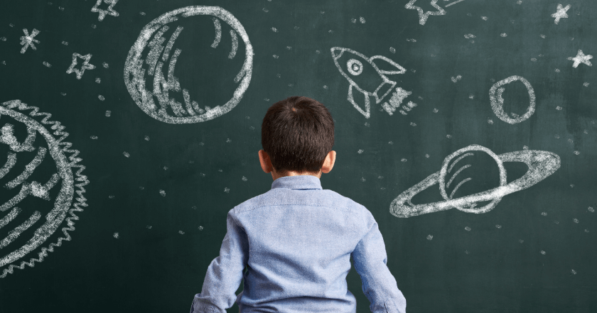 Dijete ispred školske ploče na kojoj su nacrtani planeti